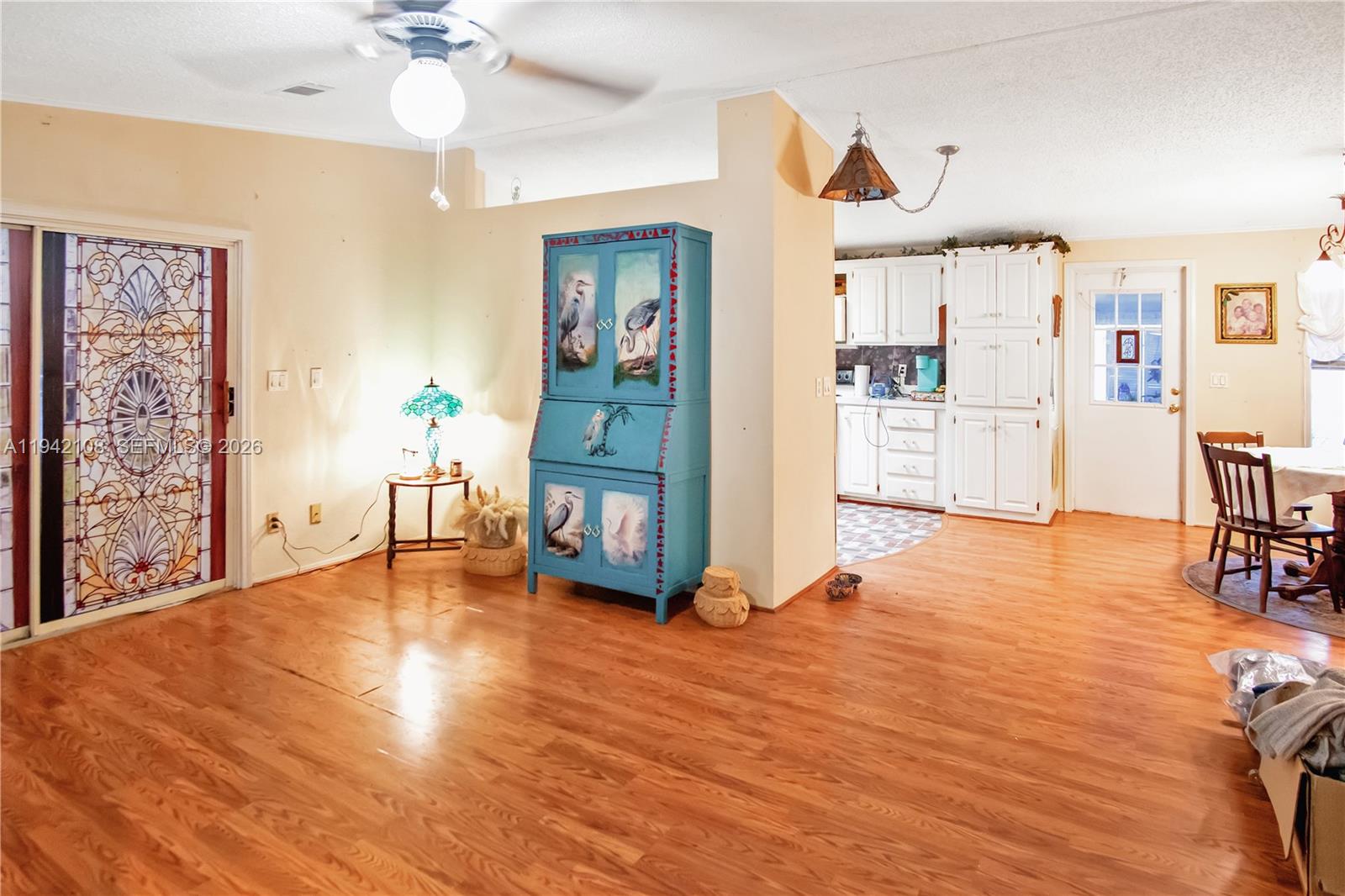 35250 Southwest 177th Court, Unit 48 Homestead, FL 33034 - Photo 6 of 29 a view of an empty room and kitchen with furniture wooden floor and window
