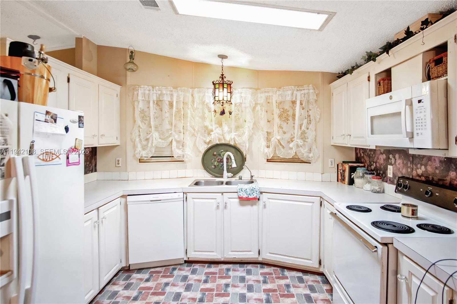 35250 Southwest 177th Court, Unit 48 Homestead, FL 33034 - Photo 9 of 29 a kitchen with a sink a stove and cabinets