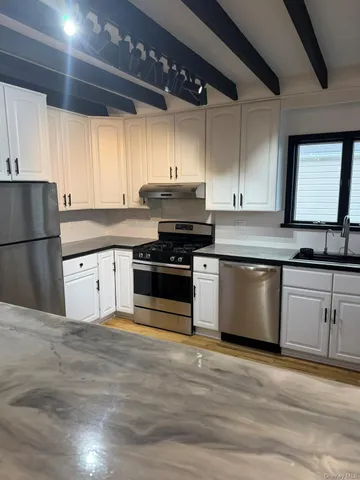 a kitchen with granite countertop a stove a sink and a refrigerator