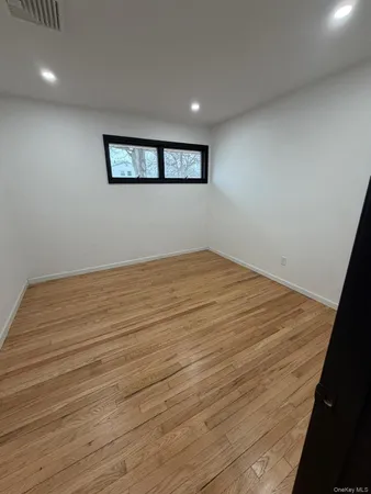 a view of a big room with wooden floor and windows