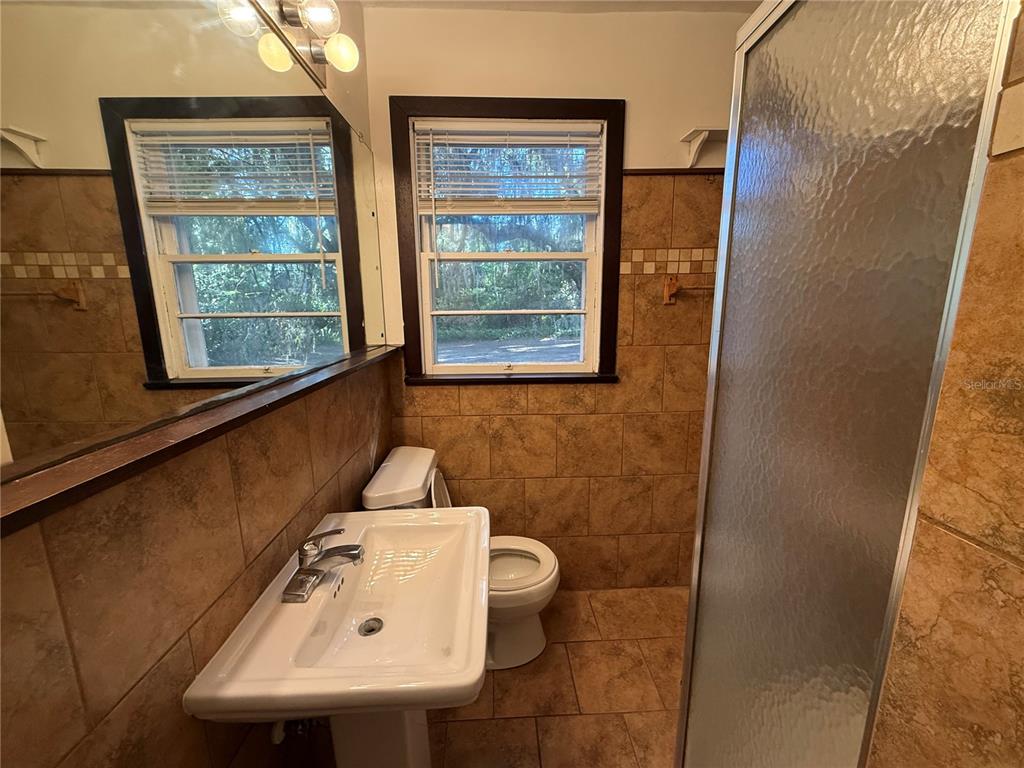403 Northwest 25 Street Gainesville, FL 32607 - Photo 4 of 14 a bathroom with a sink toilet and window