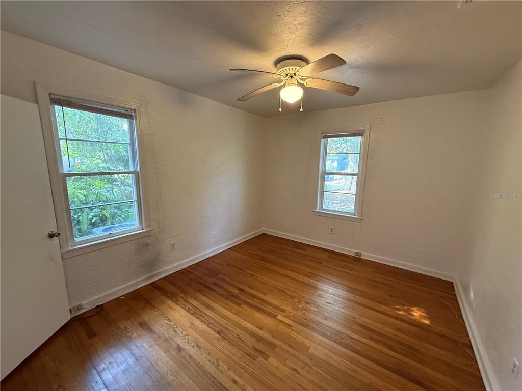 403 Northwest 25 Street Gainesville, FL 32607 - Photo 5 of 14 a view of empty room with wooden floor and fan