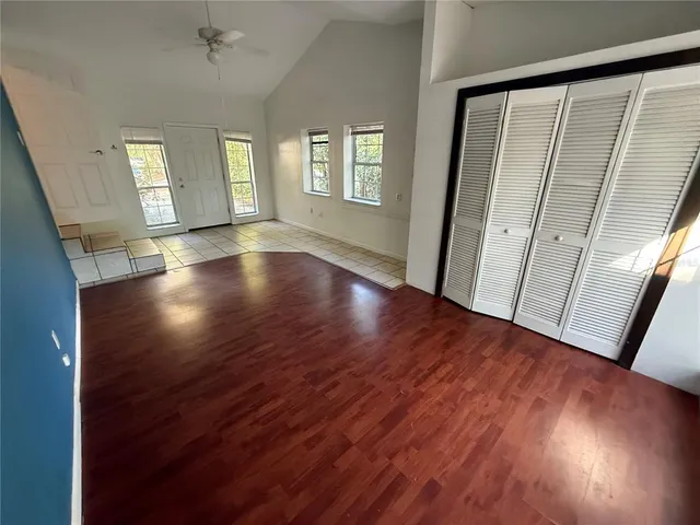 an empty room with wooden floor and windows