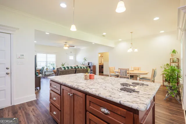 a view of a kitchen counter top space a sink wooden floor and a living room view