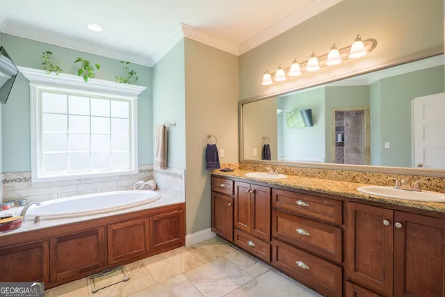 a spacious bathroom with a granite countertop double vanity sink a bathtub and a shower
