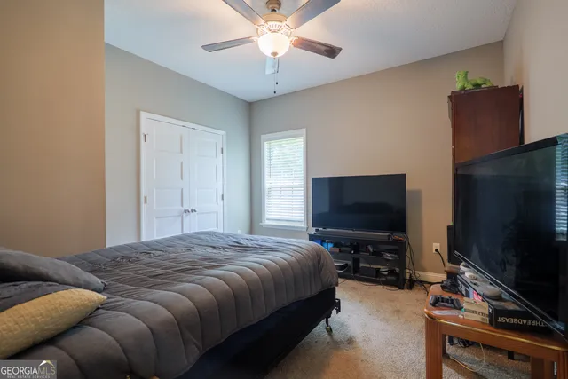 a bedroom with a bed and a flat screen tv
