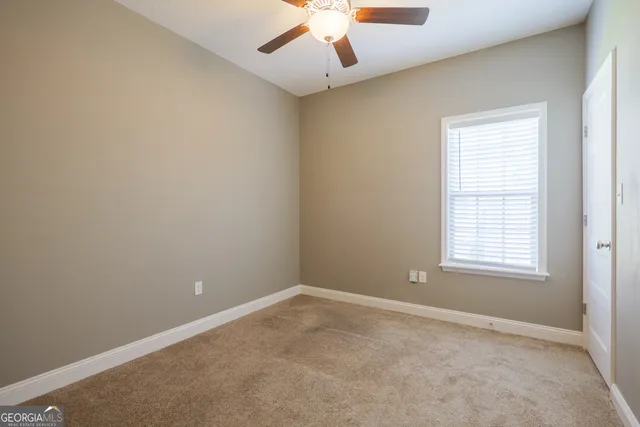 an empty room with a window and a ceiling fan
