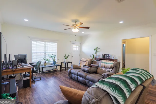 a living room with furniture ceiling fan and a wooden floor