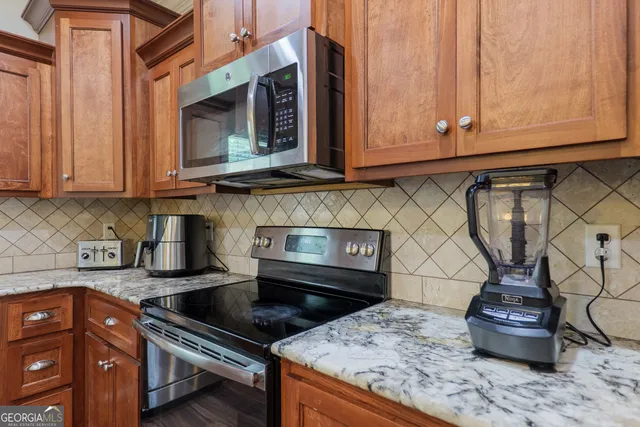 a kitchen with granite countertop a stove and cabinets