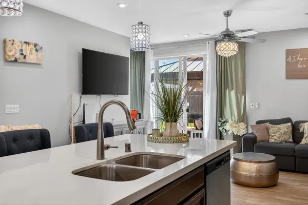 a kitchen with a faucet a chandelier and living room