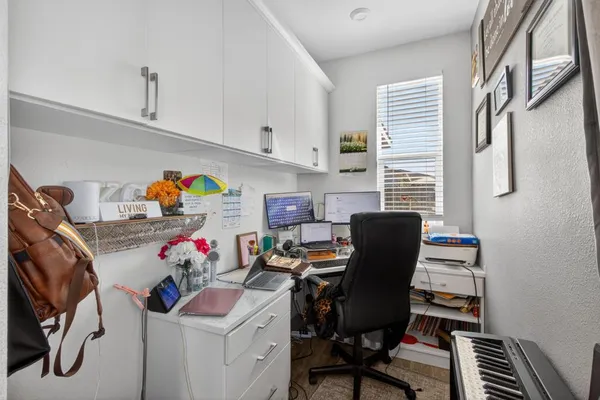 a view of a workspace with furniture and a window