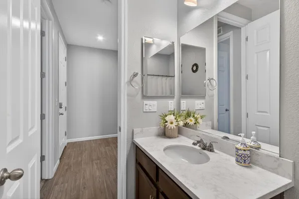 a bathroom with a sink vanity granite tub and shower