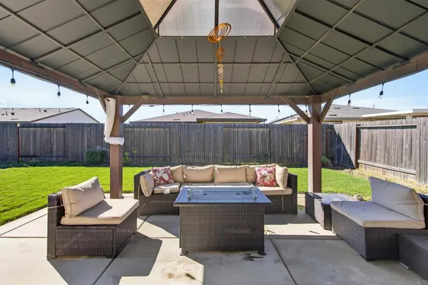 a view of a couches in patio of back yard