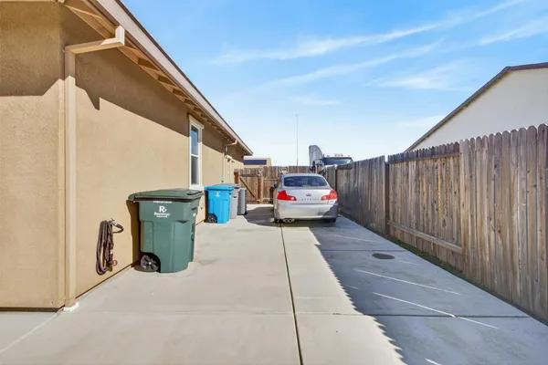 a view of a patio with table and chairs and wooden fence