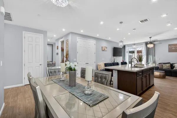 a living room with furniture a wooden floor and kitchen view