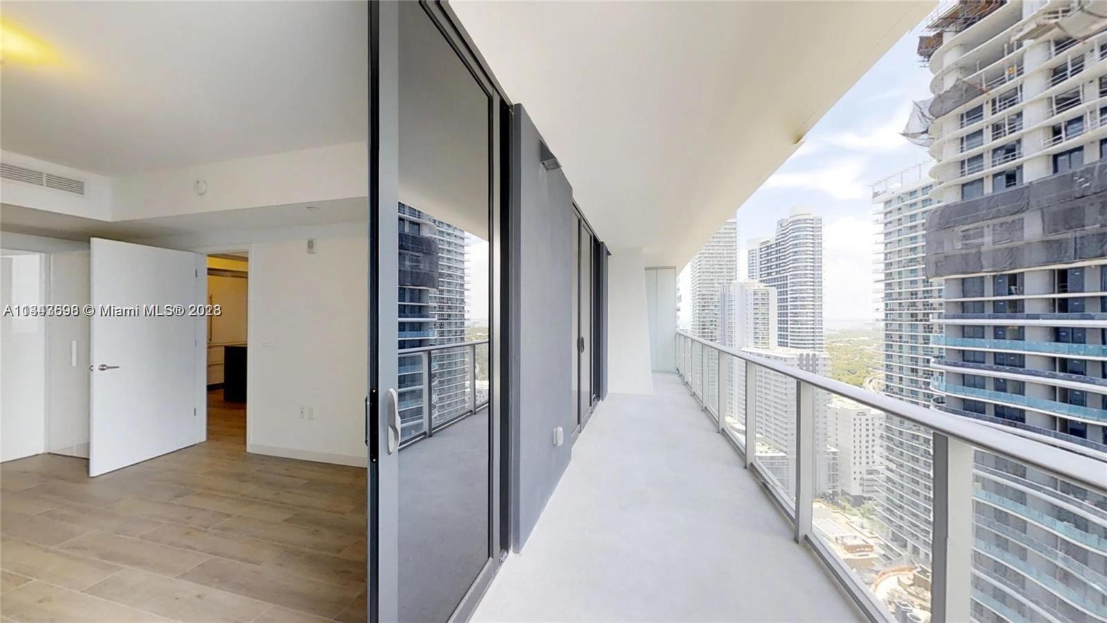 1010 Brickell Avenue, Unit 3209 Miami, FL 33131 - Photo 11 of 17 a view of a hallway with wooden floor and windows