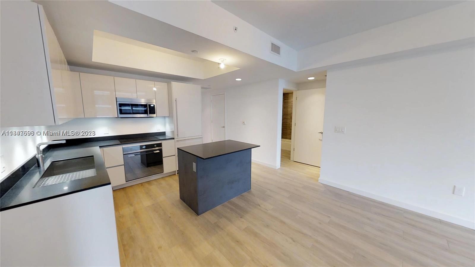 1010 Brickell Avenue, Unit 3209 Miami, FL 33131 - Photo 2 of 17 a kitchen with stainless steel appliances granite countertop a stove a sink and a refrigerator