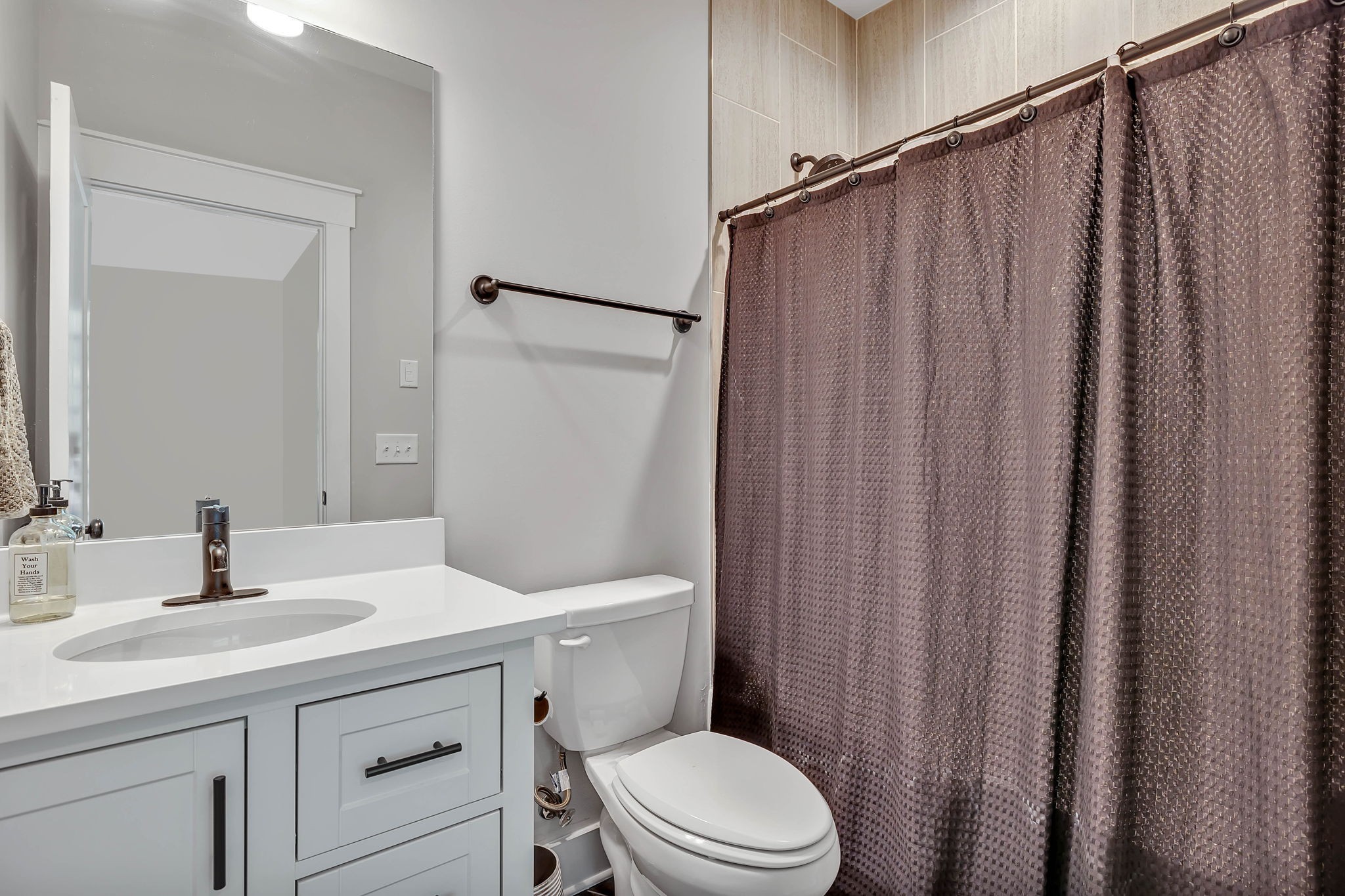 2024 Morrison Ridge Drive Nashville, TN 37221 - Photo 24 of 31 a bathroom with a sink a toilet a mirror and shower curtain