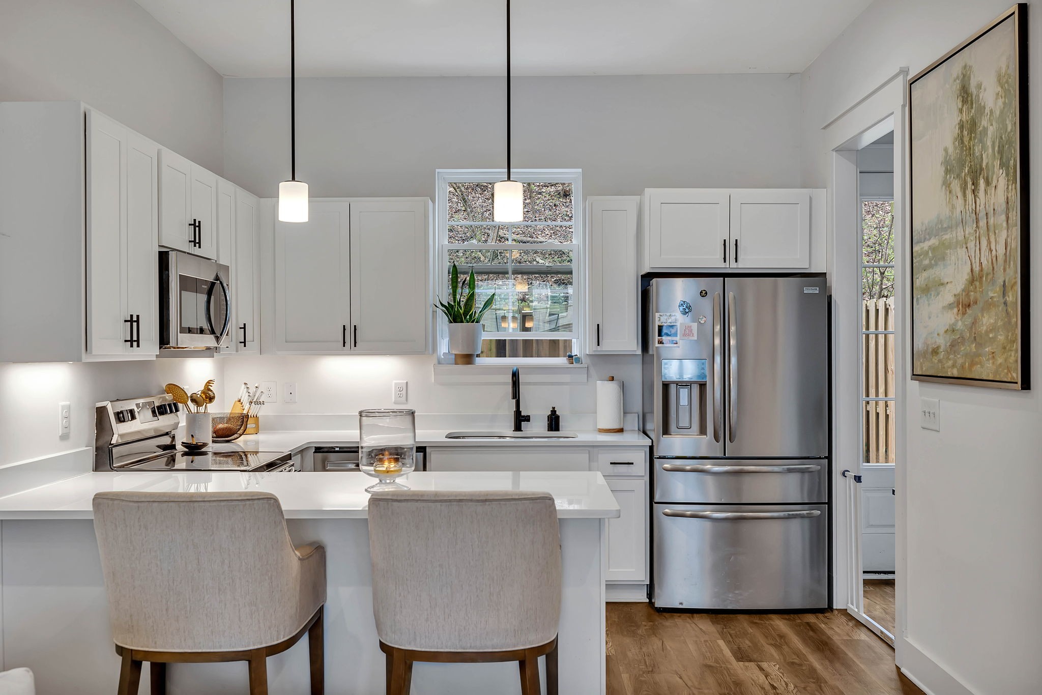 2024 Morrison Ridge Drive Nashville, TN 37221 - Photo 8 of 31 a kitchen with kitchen island a refrigerator a stove a sink and white cabinets with wooden floor