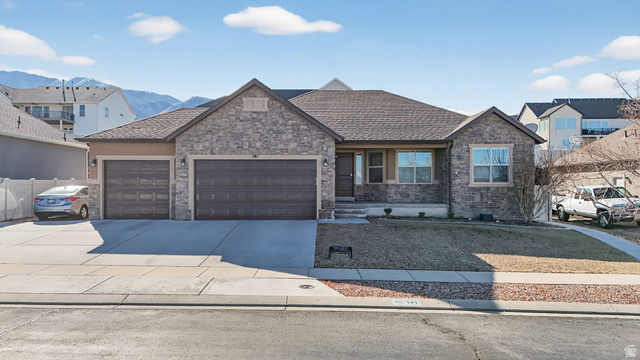 141 Wolverine Creek Elk Ridge, UT 84651 - Photo 2 of 47 View of front of home featuring driveway, an attached garage, and stone siding