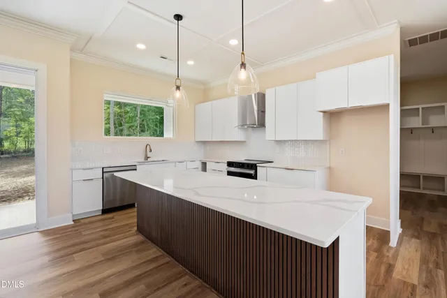 a kitchen with kitchen island a stove a sink a center island and a window