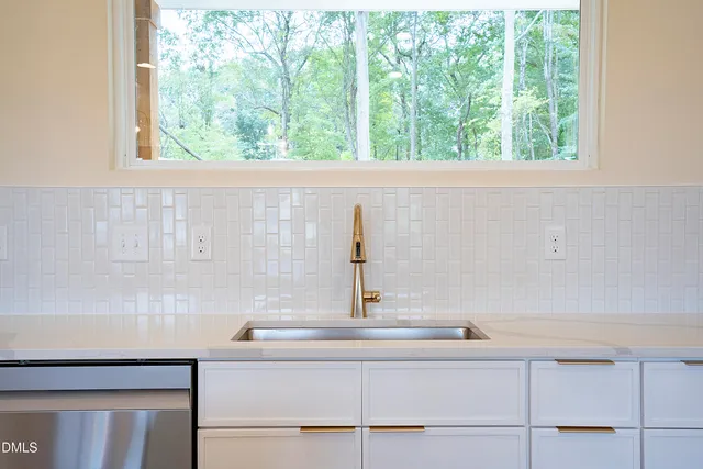 a kitchen with a sink a stove a refrigerator and a window