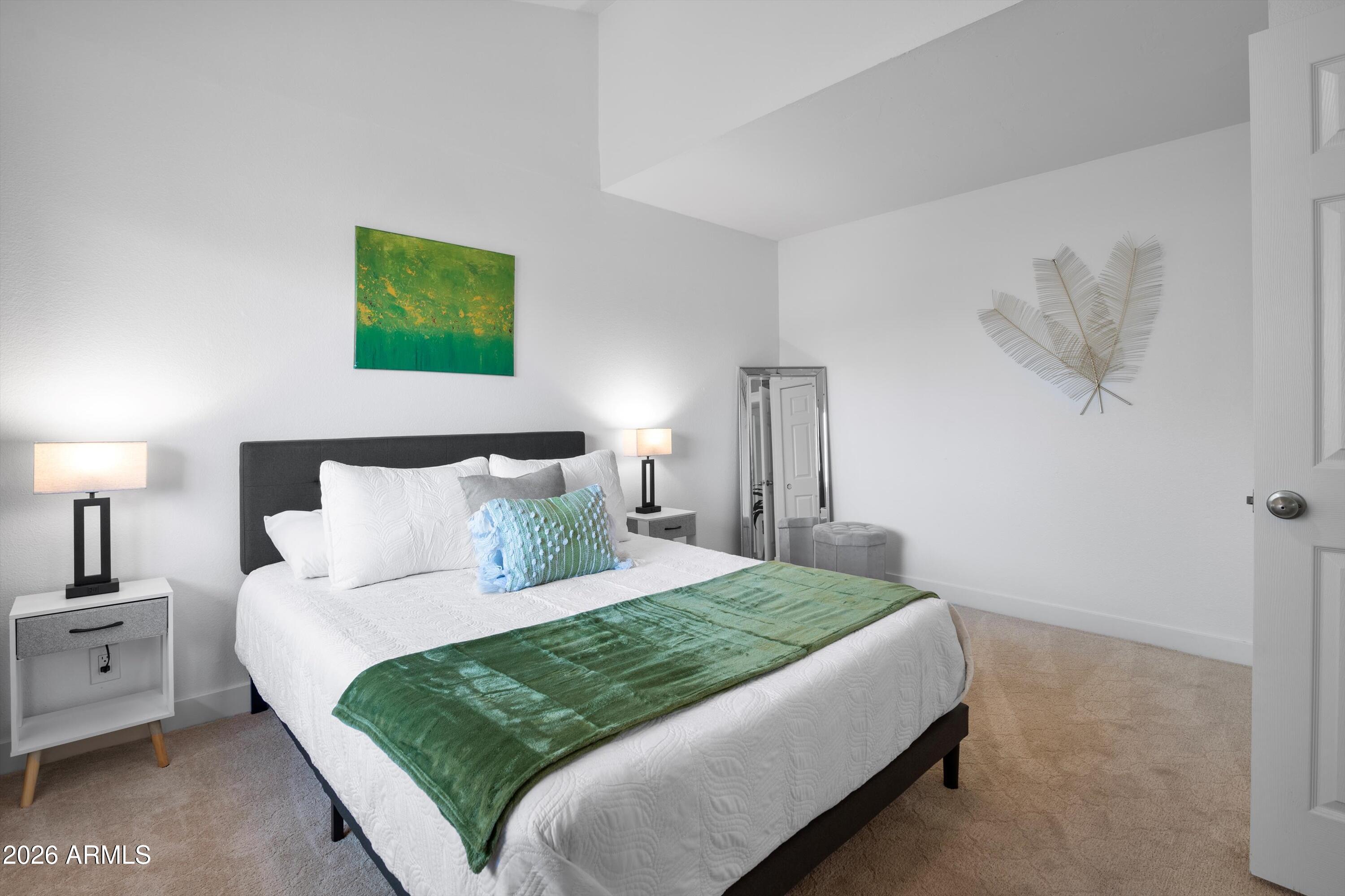 8055 East Thomas Road, Unit D105 Scottsdale, AZ 85251 - Photo 11 of 32 a bedroom with a bed and a lamp on dresser