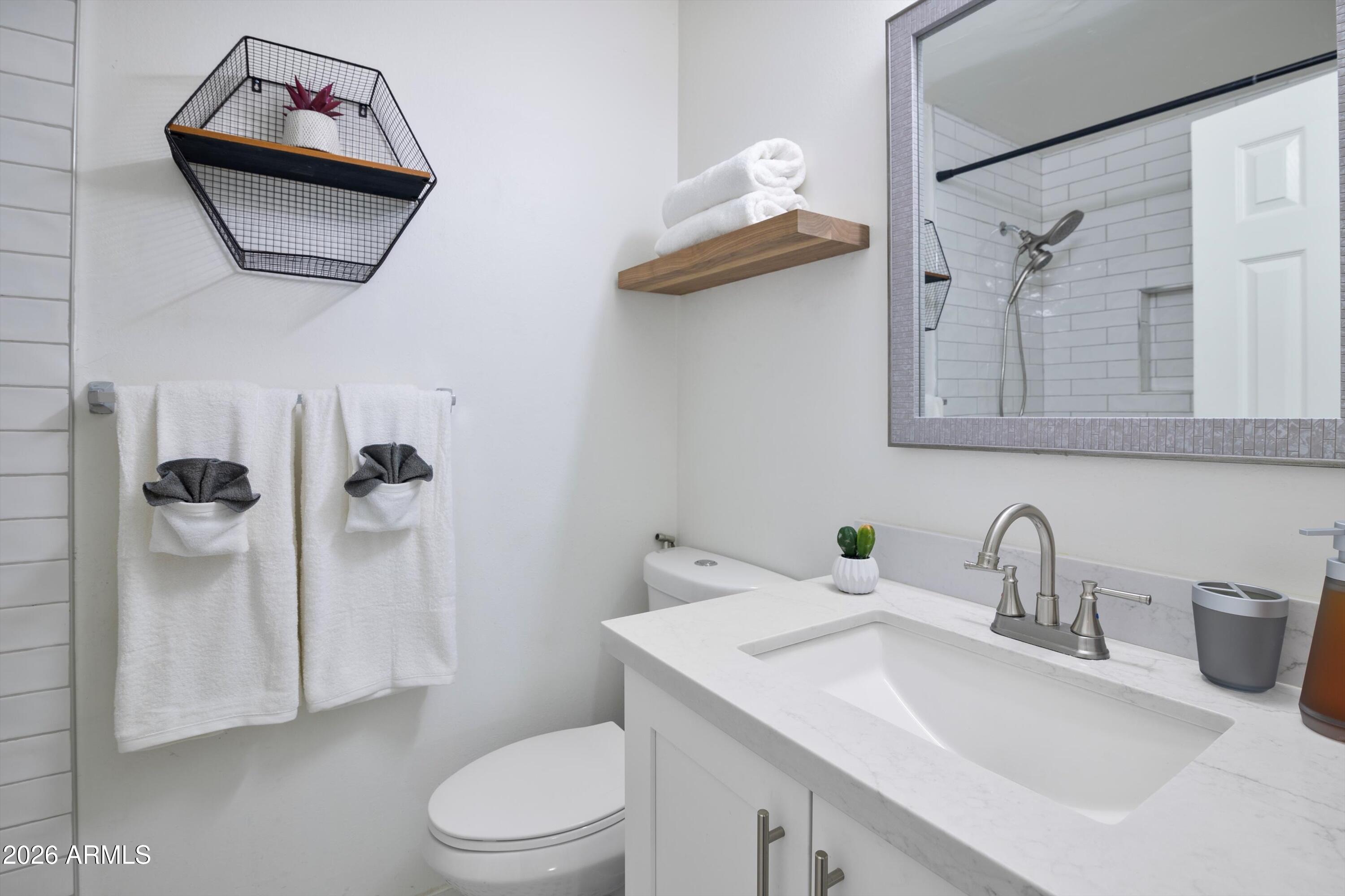 8055 East Thomas Road, Unit D105 Scottsdale, AZ 85251 - Photo 21 of 32 a bathroom with a toilet sink and mirror