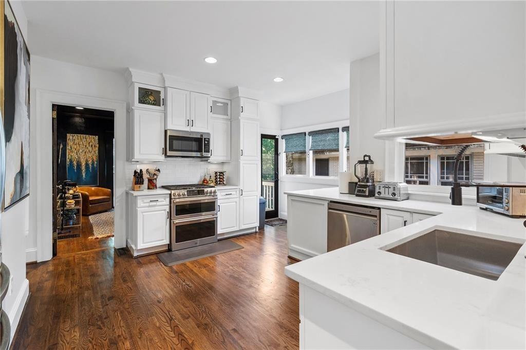 663 Yorkshire Road Northeast Atlanta, GA 30306 - Photo 23 of 85 a kitchen with stainless steel appliances kitchen island granite countertop a stove top oven a sink a dining table and chairs