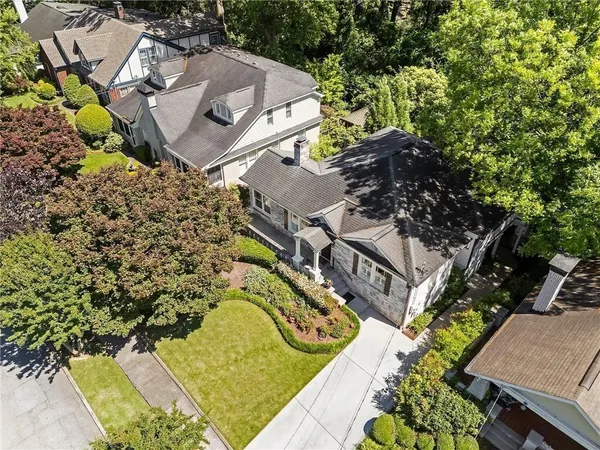 an aerial view of residential house with outdoor space and trees all around