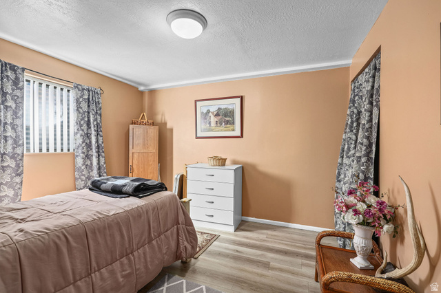 1120 Canyon Road, Unit 38 Ogden, UT 84404 - Photo 23 of 24 Bedroom featuring a textured ceiling and light wood finished floors