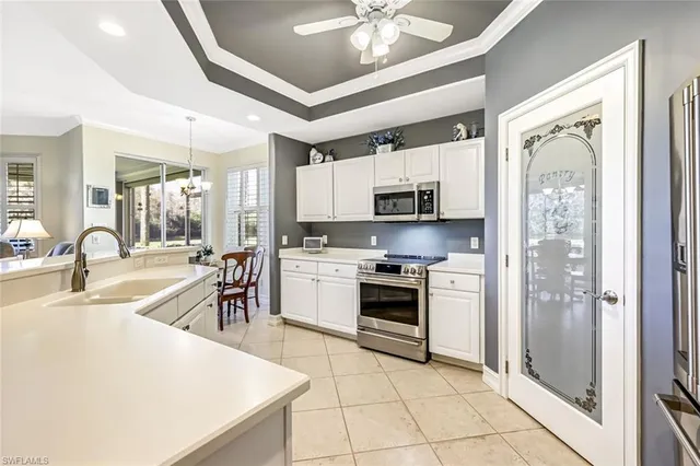 a kitchen with stainless steel appliances kitchen island granite countertop a refrigerator a stove top oven and sink