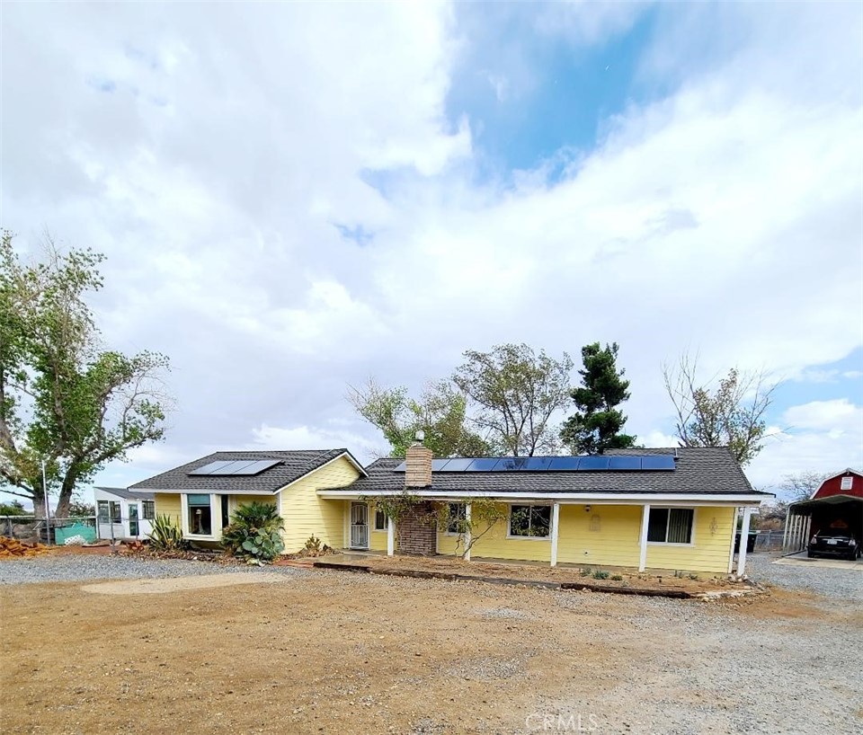 a view of a house with a big yard and large trees