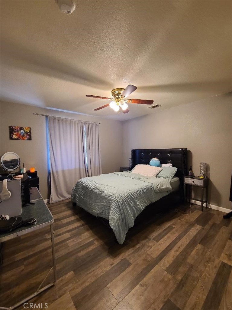 8725 Monte Vista Road Phelan, CA 92371 - Photo 14 of 31 a bedroom with a bed and a chandelier