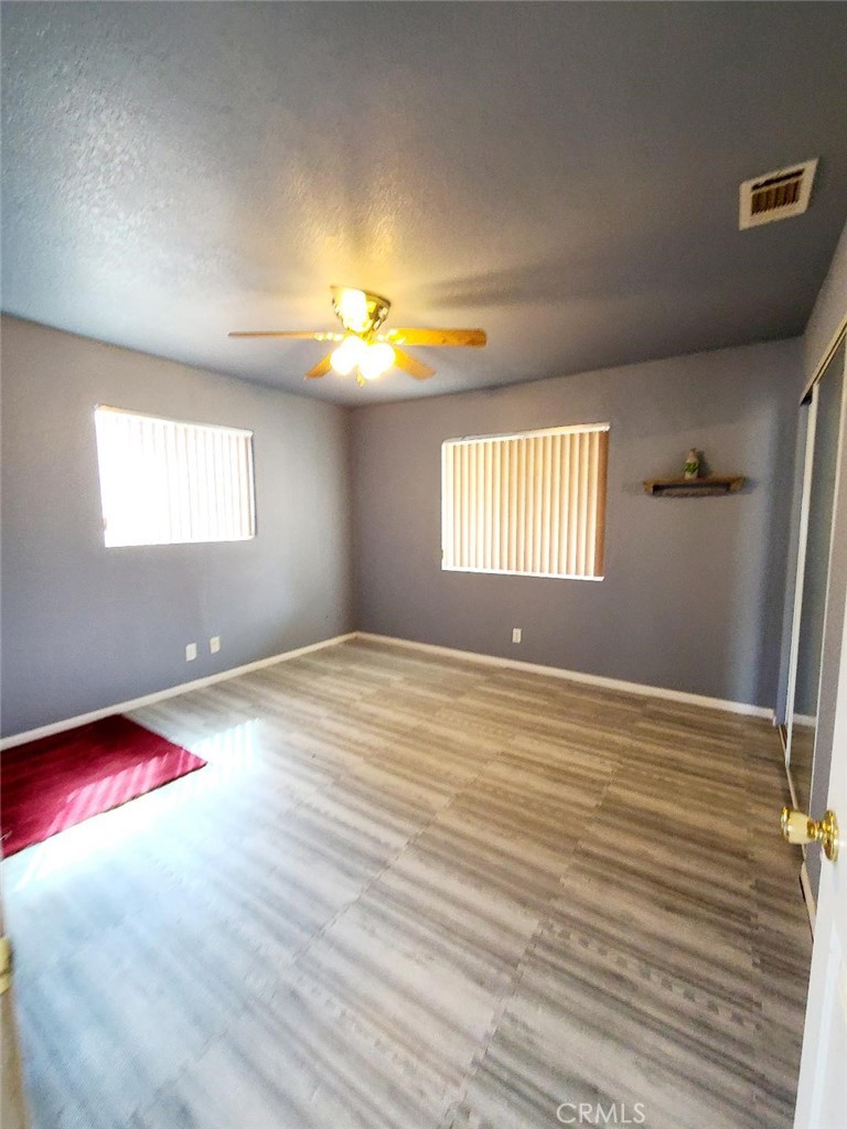 8725 Monte Vista Road Phelan, CA 92371 - Photo 15 of 31 a view of empty room with window and wooden floor