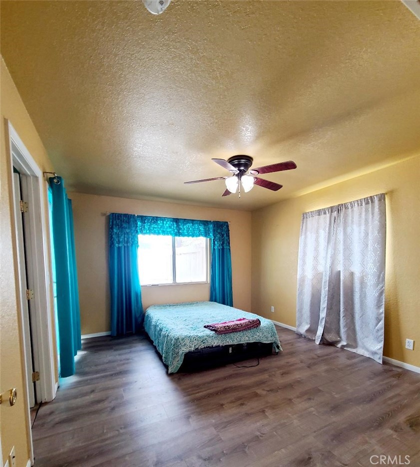 8725 Monte Vista Road Phelan, CA 92371 - Photo 16 of 31 a bedroom with a bed and a chandelier