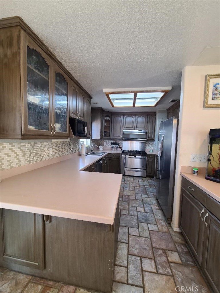 8725 Monte Vista Road Phelan, CA 92371 - Photo 19 of 31 a kitchen with stainless steel appliances granite countertop a sink stove and refrigerator