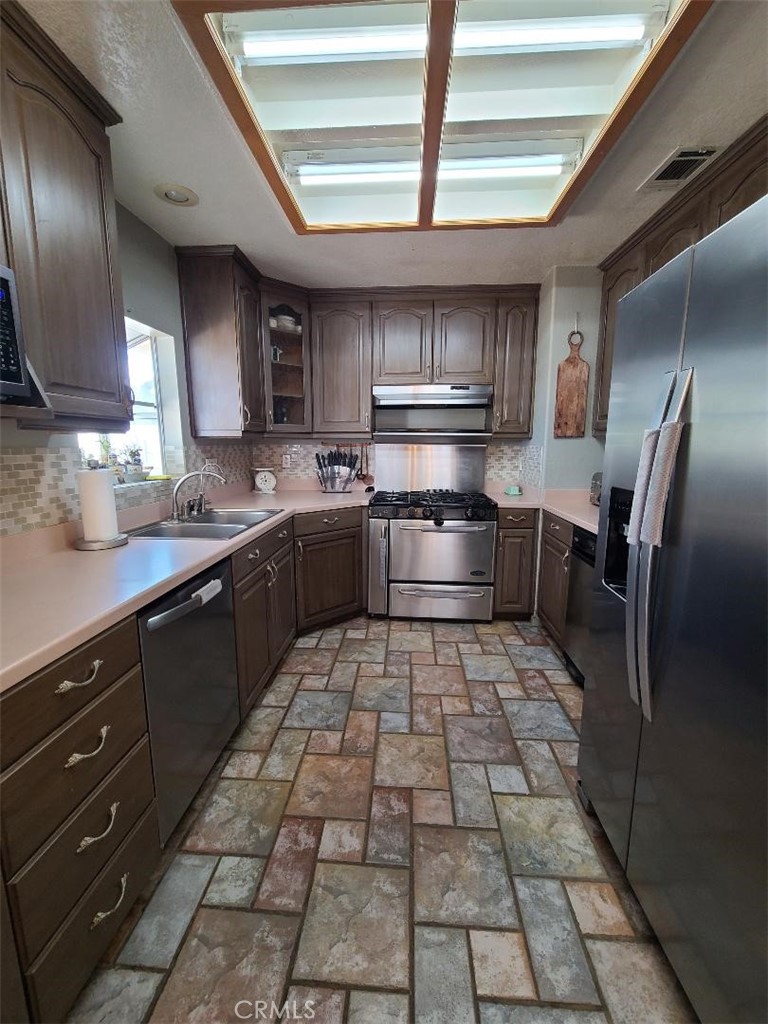 8725 Monte Vista Road Phelan, CA 92371 - Photo 20 of 31 a kitchen with stainless steel appliances granite countertop a sink stove and refrigerator