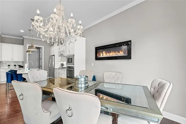 a living room with furniture a chandelier and kitchen view