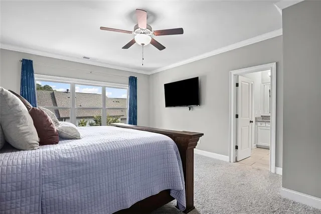 a bedroom with a bed tv and a window