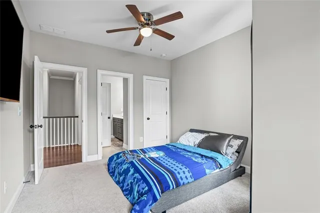 a bedroom with a bed and a ceiling fan
