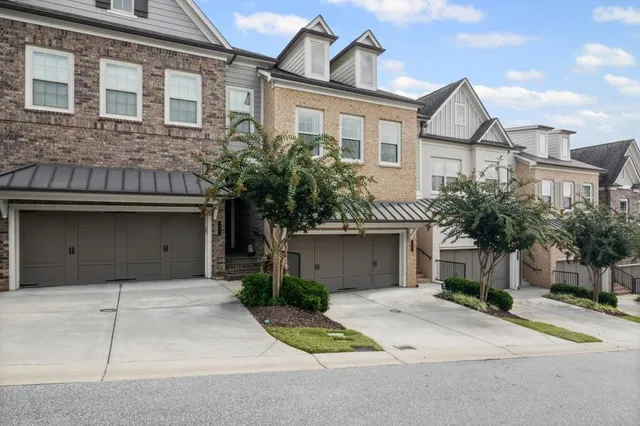 a front view of a house with a garden and garage