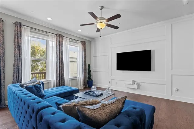 a living room with furniture a flat screen tv and a large window