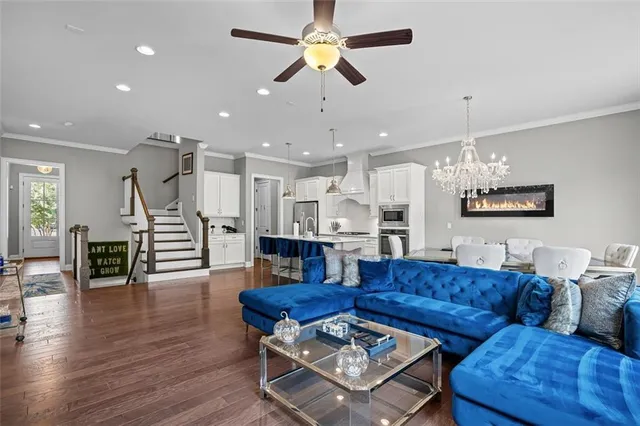 a living room with furniture kitchen view and a chandelier