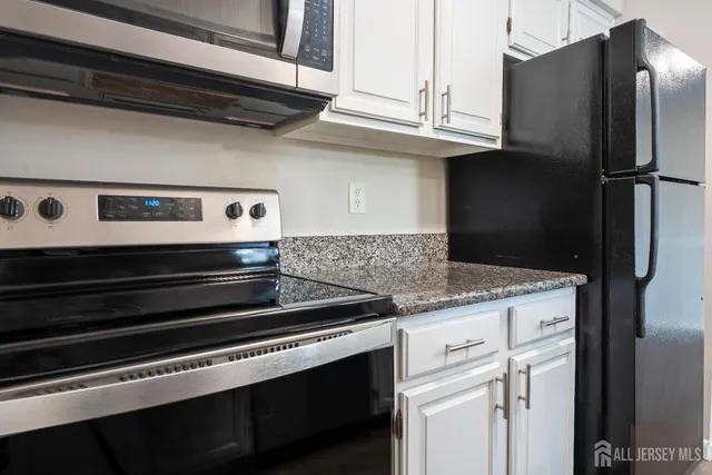 a kitchen with stainless steel appliances granite countertop a refrigerator and a stove
