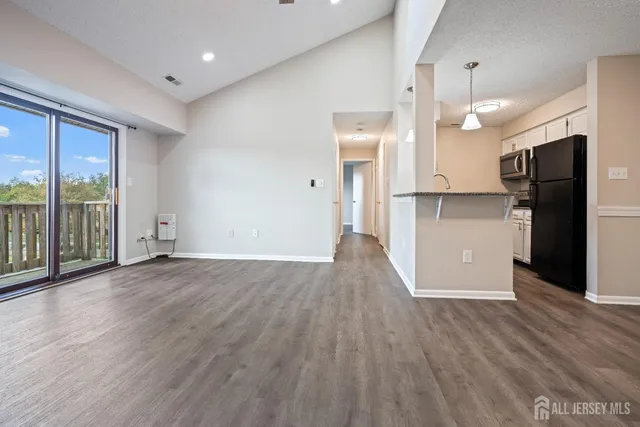 a view of a kitchen with wooden floor and a refrigerator