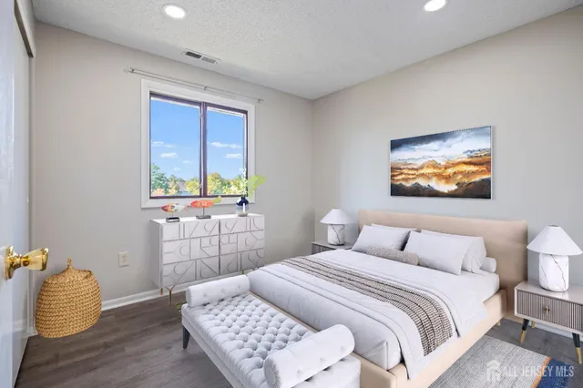 a bedroom with a bed and a painting on the wall