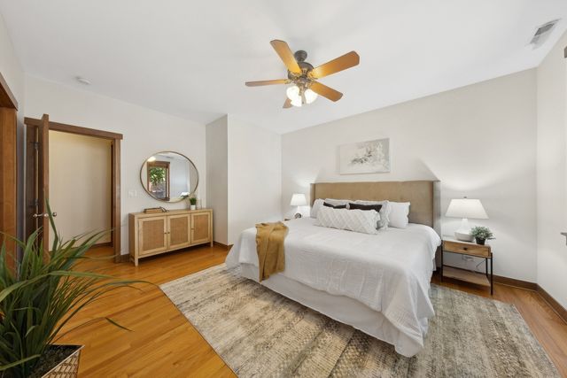 a bedroom with a bed a mirror and a lamp on table