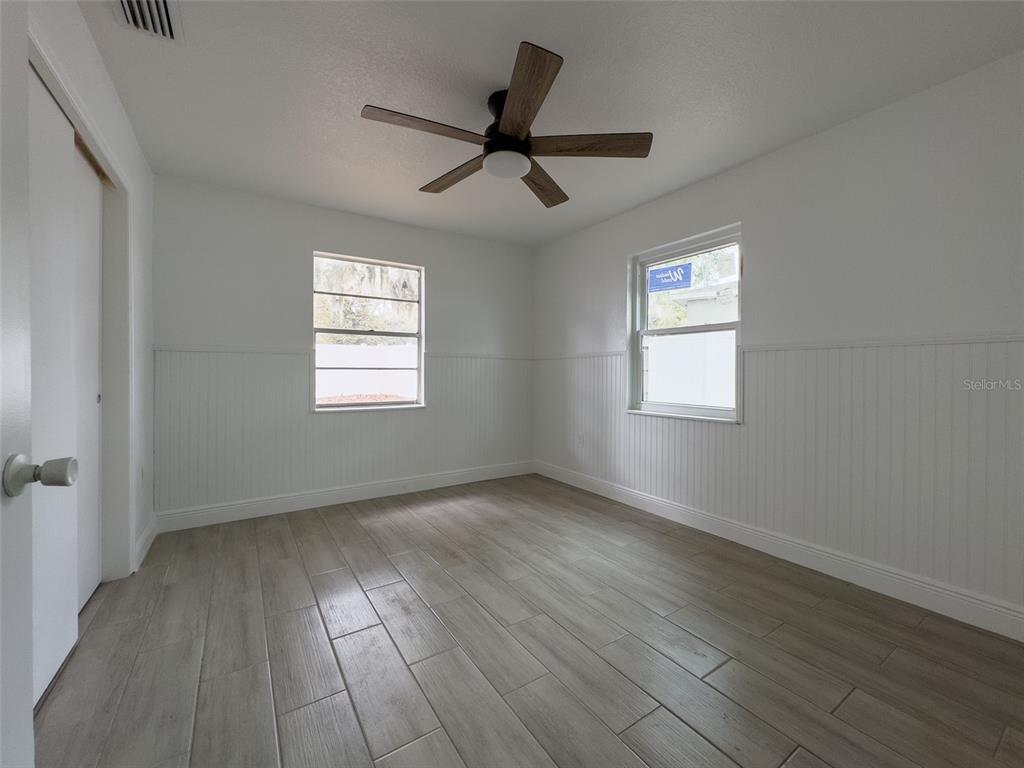 1047 Clay Boulevard Eustis, FL 32726 - Photo 15 of 33 a view of an empty room with wooden floor and a window