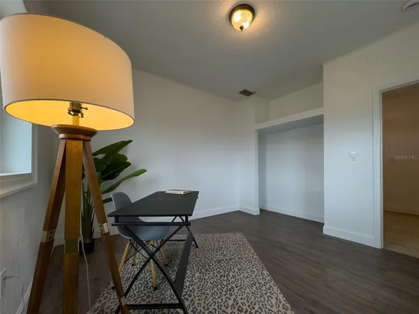 a workspace room with furniture and a potted plant